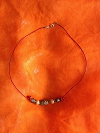 Collier perle en terre, bois et métal sur cordon rouge